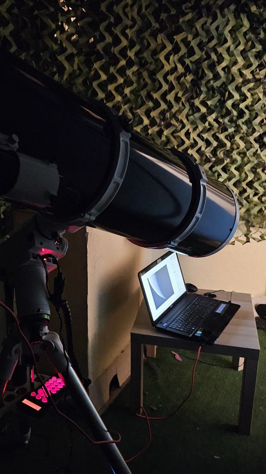 Maksutov 127 AZ GoTo apuntando al cielo junto a un portátil con software de captura